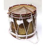 A military type brass drum, 36cms diameter and a pair of drumsticks.
