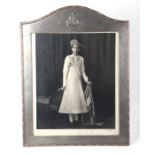 A large Bombay silver strut photo frame with crested top containing a signed and annotated black &