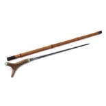 A bamboo shafted sword stick with a 50cms (19.75ins) triangular section blade and stag horn