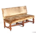 A late Victorian upholstered carved oak hall bench with carved urn shaped front supports joined by