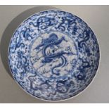 A Chinese blue & white plate decorated with dragons amongst clouds chasing a flaming pearl, blue