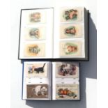 Two postcard albums containing anthropomorphic cat postcards to include examples by Louis Wain and