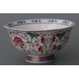 A Chinese famille rose footed bowl decorated with scrolling flowering foliage with a blue & white