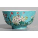 A Chinese famille rose footed bowl decorated with flowers on turquoise ground, four character mark