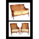 A beech three-piece bergere suite with double caned backs.
