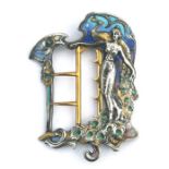 An Art Nouveau white and gilt metal enamelled buckle in the form of a sinuous lady, 7.7cms high.