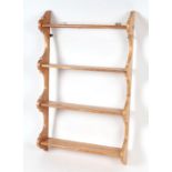 A set of four-tier stripped pine open wall shelves, 62cms wide.