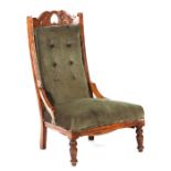 A late Victorian upholstered button back nursing chair with turned front legs.