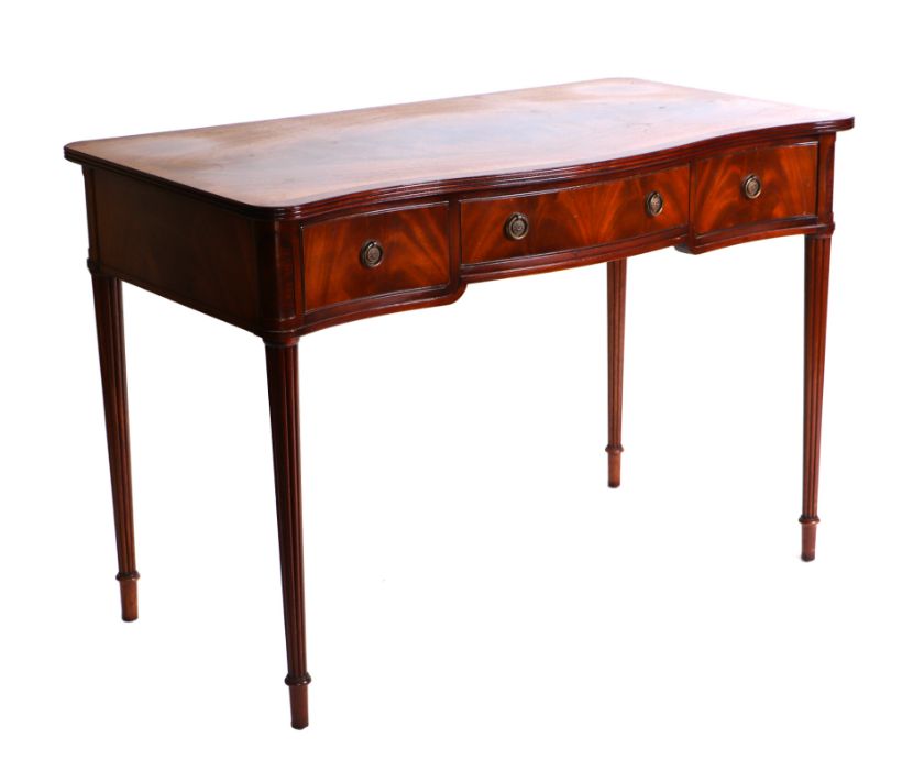 A 19th century style serpentine mahogany side table with three frieze drawers, on reeded tapering