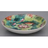 A Chinese saucer dish decorated with lotus flowers, six character red mark to the underside, 13.5cms