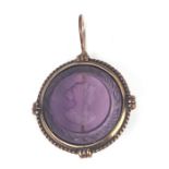 An amethyst glass intaglio pendant depicting the bust of a young lady, 2.5cms diameter.