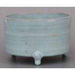 A Chinese celadon glazed tripod censer, 14cms diameter.