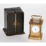A Goldsmiths & Silversmiths miniature brass cased carriage time piece, 9cms high, in original faux