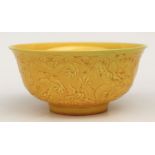 A Chinese Imperial yellow glaze footed bowl with moulded decoration depicting dragons amongst