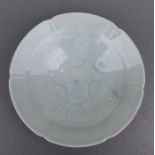 A Chinese pale celadon glaze shallow footed dish with incised decoration, 16cms diameter.