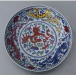 A Chinese Ducai style shallow dish decorated with a phoenix amongst scrolling foliage, six character