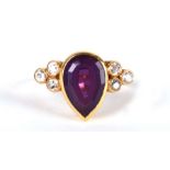 An 18ct gold ring set with a central pear shaped amethyst and diamond set shoulders, approx UK