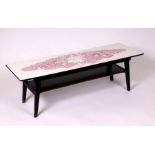 A mid 20th century design two tier coffee table, the top decorated a flower seller. 115cm wide