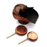 A copper coal scuttle and shovel; together with two copper pans (3).