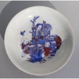 A Chinese blue, white and red shallow bowl decorated with a robed lady with small boys, six