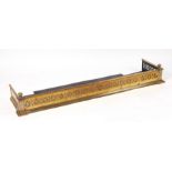 A Victorian pierced brass fire curb, 140cms wide.