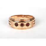 A 9ct gold three-stone ruby gypsy ring, approx UK size 'S', 7.7g.