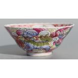 A Chinese famille rose bowl decorated with Shishi amongst clouds with peaches and flowers to the