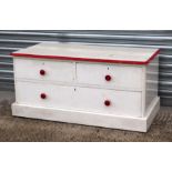 A painted pine low chest of two short and one long drawer, on a plinth base, 107cms wide.