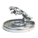 A 1960's Jaguar Dealer Showroom aluminium ashtray surmounted with a leaping Jaguar mascot, 18cms