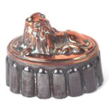 A Victorian copper and tin jelly mould in the form of a recumbent lion, numbered F56, 18cms wide.