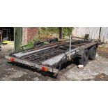 A twin axle car transporter with manual winch and trailer board, approx 14ft in length.