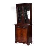 A 19th century mahogany bookcase on cupboard, the pair of astragal glazed doors enclosing a