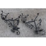 A pair of wrought iron wall light brackets with scroll decoration, each 50cms wide (2).