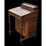 A late Victorian walnut Davenport with an arrangement of four real and four faux drawers and a