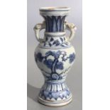 A Chinese blue & white baluster vase with elephant handles and foliate decoration, 23cms high.