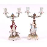 A pair of 19th century continental porcelain figural candelabra, each with flower encrusted