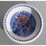 A Chinese rimmed shallow blue, white & red dish decorated with a bird and fruit, six character