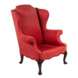 A George III style wingback armchair on mahogany cabriole front legs.