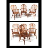 A set of seven beech and elm 19th century style Windsor arm chairs with pierced back splats, hoop