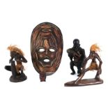 An African carved wood tribal figure, 25cms high; together with two similar and a carved and painted