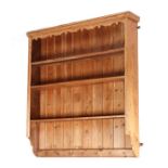 A pine four-tier plate rack with boarded back, 103cms wide.