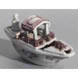 A Chinese manganese glaze water dropper in the form of a boat with figures, 20cms long.