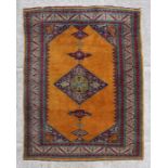 A Persian rug with geometric design on a golden ground, 128 by 185cms.