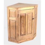 A striped pine corner cabinet, the panelled door enclosing a shelved interior, 83cms wide.