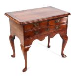 A 19th century walnut and crossbanded lowboy in the George II style with an arrangement of two short