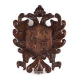 A carved oak heraldic shield, 38cms wide.