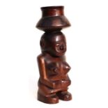 An East African tribal art (Tanzania) carved hardwood squat female figure with pokerwork decoration,
