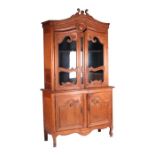 A late 19th century French pitch pine bookcase on cabinet, the upper section with a moulded and