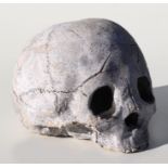 A cast reconstituted stone human skull paperweight, approx 15cms wide.