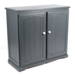 A modern painted pine cupboard, the pair of panelled doors enclosing a shelved interior, on a plinth